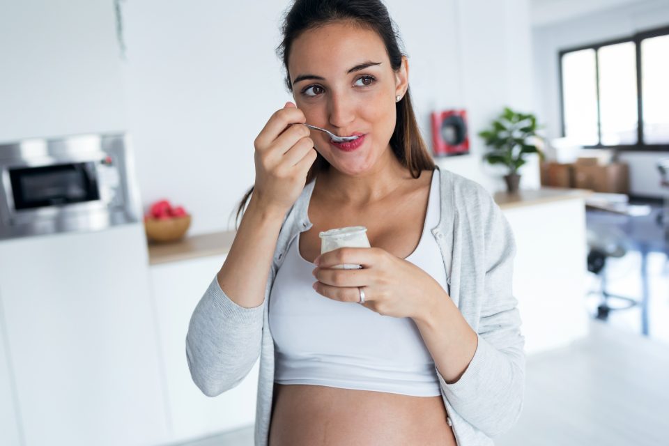 Femme enceinte mangeant un yaourt